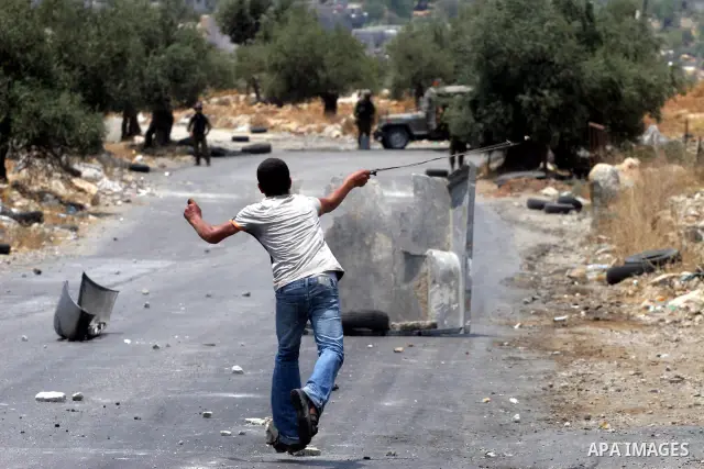 Palestinian youths hurl stones at Israeli soldiers during a demonstration against the construction of the controversial Israeli cement barrier in the West Bank village of Nilin near Ramallah.