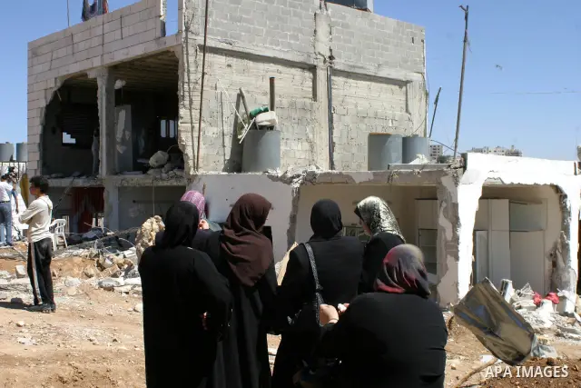 Palestinians react as they inspect their destroyed house of Jamal Karameh in the West Bank town of Hebron. According to Palestinian witnesses, Israeli forces raided two houses and arrested several men during an early mor...
