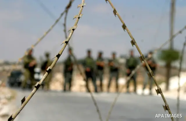 Israeli soldiers monitor a demonstration by Palestinian and foreign protestors against the construction of the controversial Israeli separation barrier in the West Bank village of Maasarah near Bethlehem.