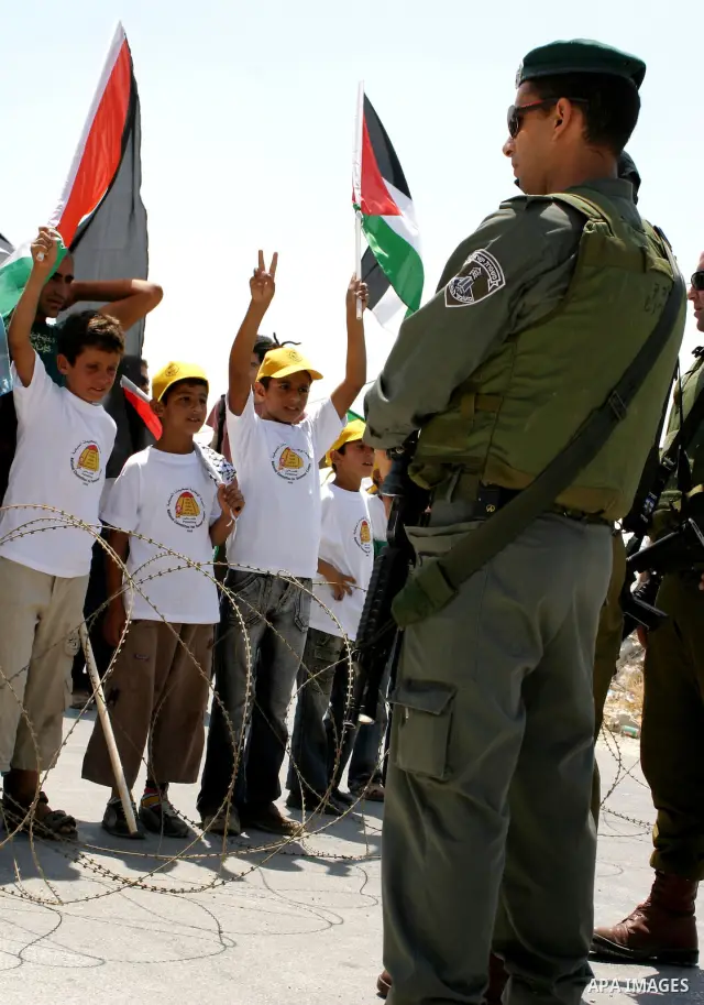 Israeli soldiers monitor a demonstration by Palestinian and foreign protestors against the construction of the controversial Israeli separation barrier in the West Bank village of Maasarah near Bethlehem.