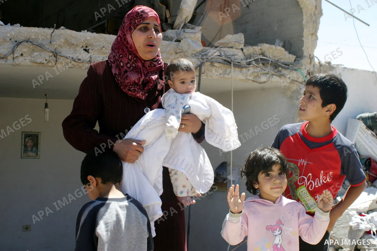 Palestinians react as they inspect their destroyed house of Jamal Karameh in the West Bank town of Hebron. According to Palestinian witnesses, Israeli forces raided two houses and arrested several men during an early mor...