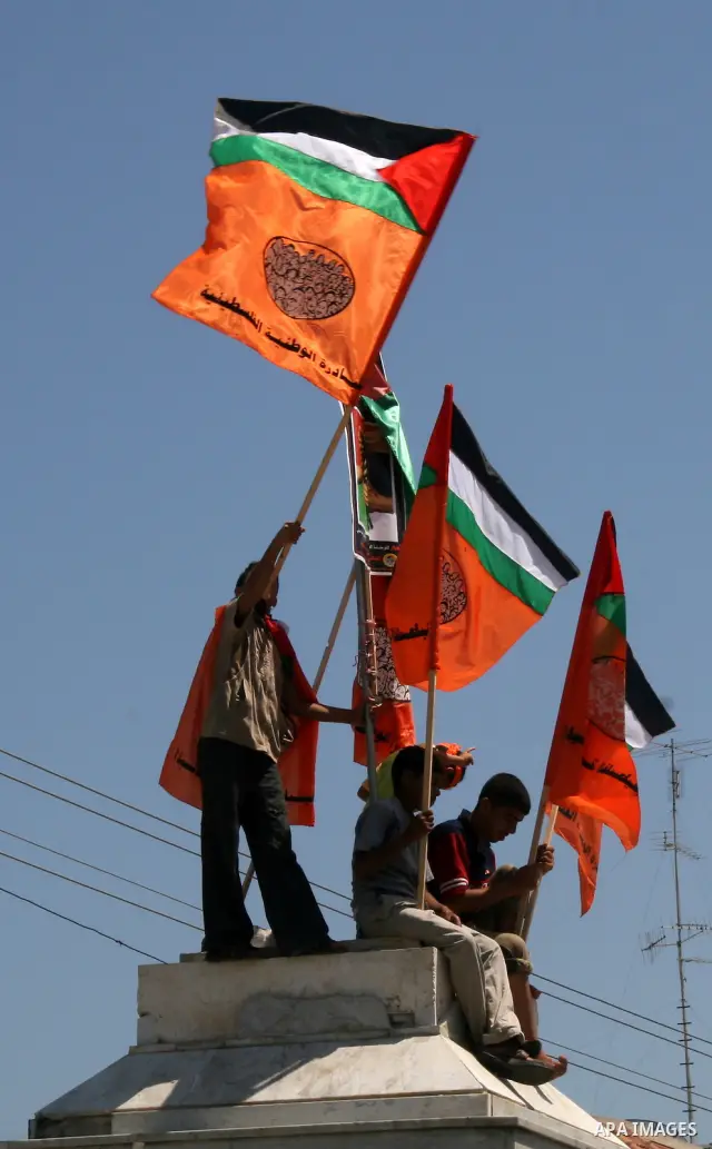 Palestinians hold their country's flag and placards as they attend a rally calling for the national conciliation and end the difference between Hamas and Fatah parties, in Gaza City.