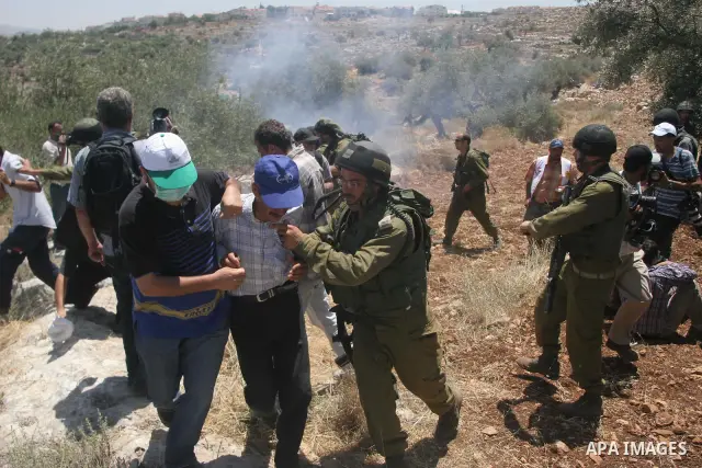 Israeli soldiers scuffle with protesters during a demonstration against the construction of Israel's controversial barrier in the West Bank village of Nilleen near Ramallah.. Israel says the barrier, which would eventual...
