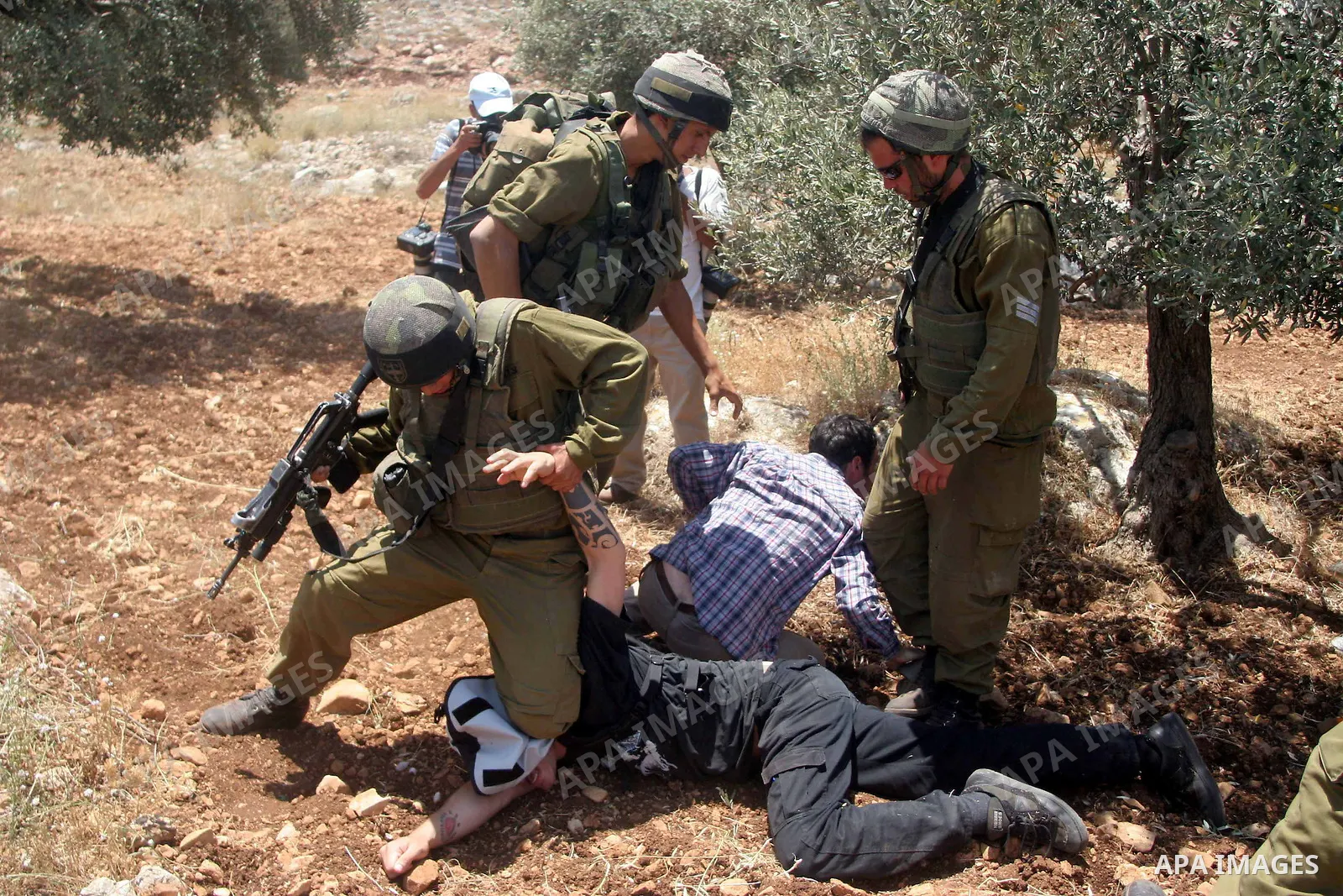 Israeli soldiers scuffle with protesters during a demonstration against the construction of Israel's controversial barrier in the West Bank village of Nilleen near Ramallah.. Israel says the barrier, which would eventual...