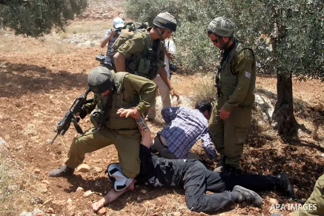 Israeli soldiers scuffle with protesters during a demonstration against the construction of Israel's controversial barrier in the West Bank village of Nilleen near Ramallah.. Israel says the barrier, which would eventual...