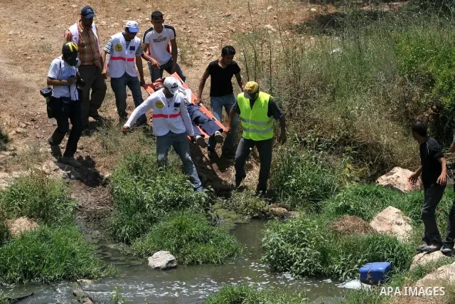 Protesters carry a Palestinian wounded during a demonstration against the construction of the controversial Israeli barrier in the West Bank village of Nilleen near Ramallah. Israel says the barrier, which would eventual...