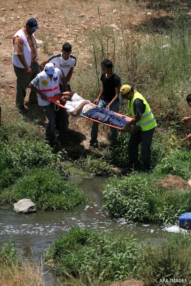 Protesters carry a Palestinian wounded during a demonstration against the construction of the controversial Israeli barrier in the West Bank village of Nilleen near Ramallah. Israel says the barrier, which would eventual...