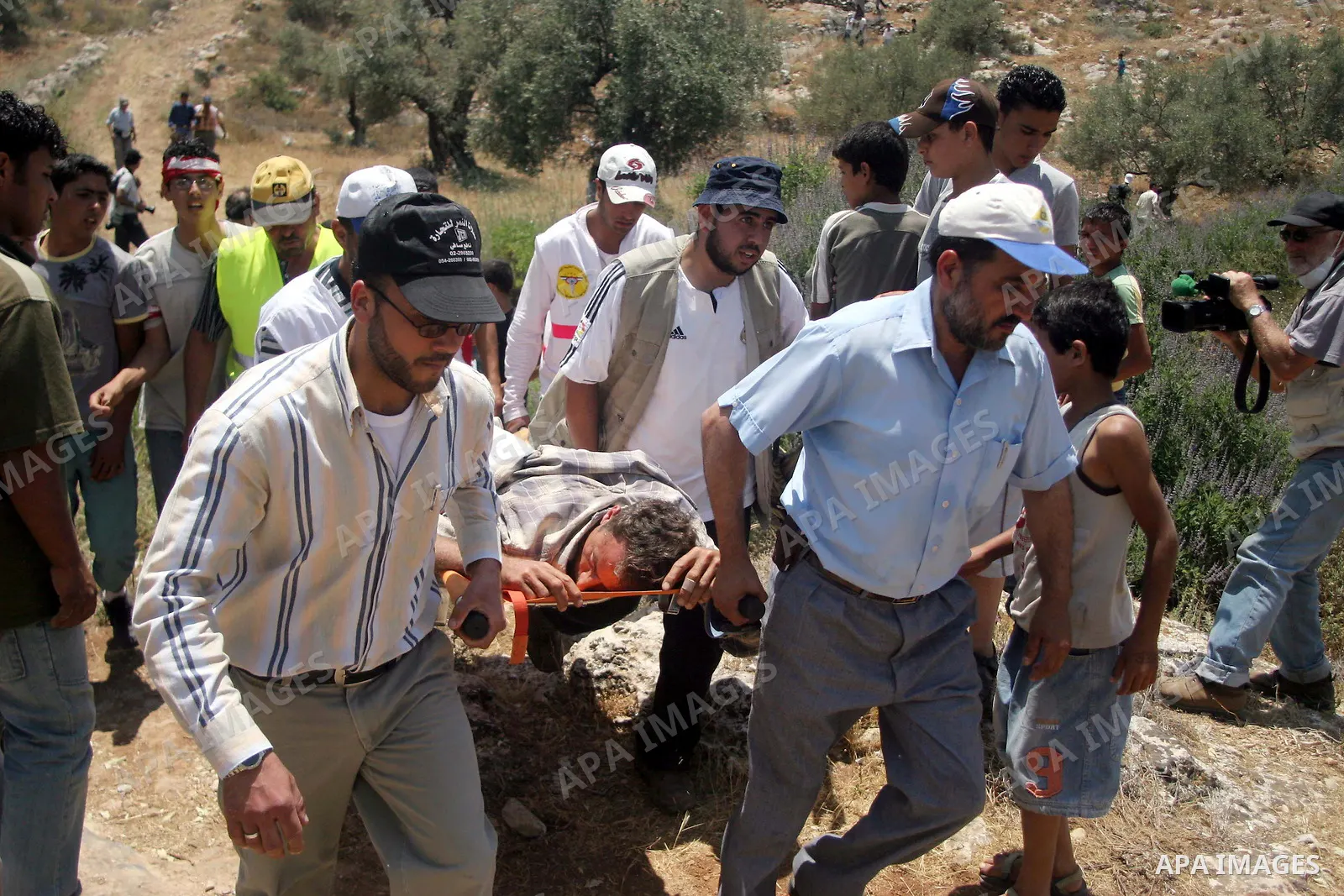 Protesters carry a Palestinian wounded during a demonstration against the construction of the controversial Israeli barrier in the West Bank village of Nilleen near Ramallah. Israel says the barrier, which would eventual...