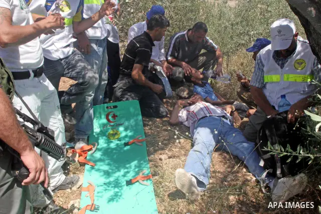 A young Palestinian boy and his father get first aid after succumbing to tear-gas fired by Israeli troops during a violent protest against the construction of Israel's controversial security fence in the West Bank villag...