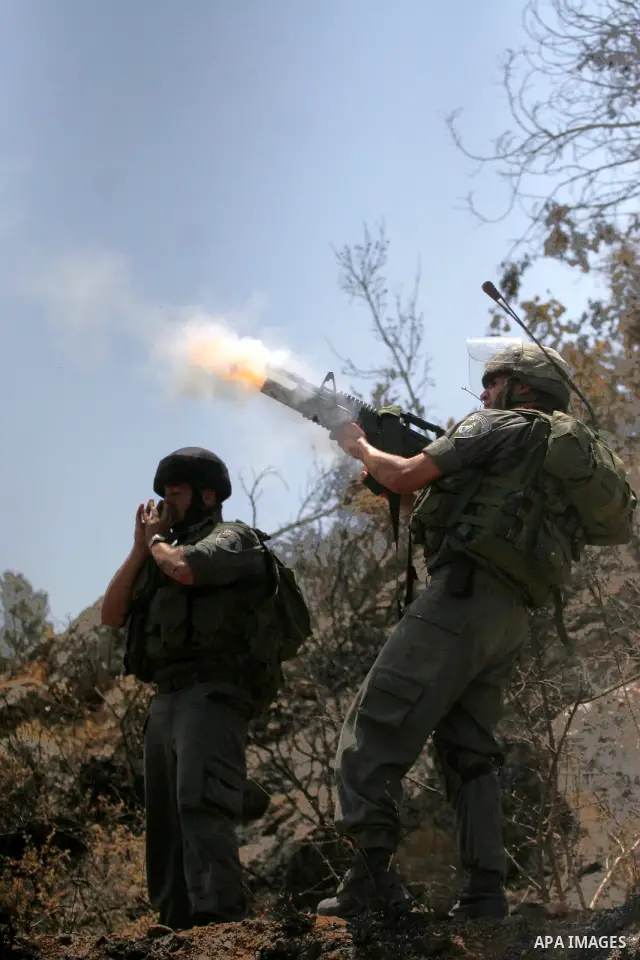 Israeli border police officers fire teargas at Palestinian stone-throwers during a violent protest against the construction of Israel's controversial security fence in the West Bank village of Nilin, west of Ramallah.