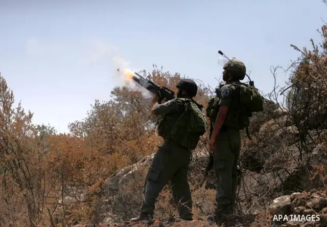 Israeli border police officers fire teargas at Palestinian stone-throwers during a violent protest against the construction of Israel's controversial security fence in the West Bank village of Nilin, west of Ramallah.