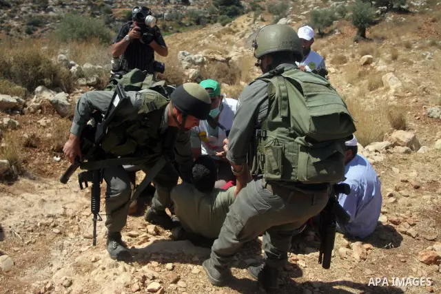 Israeli border police scuffle with Palestinians and international peace protesters during a demonstration against the construction of the controversial Israeli barrier in the West Bank village of Nilleen near Ramallah.