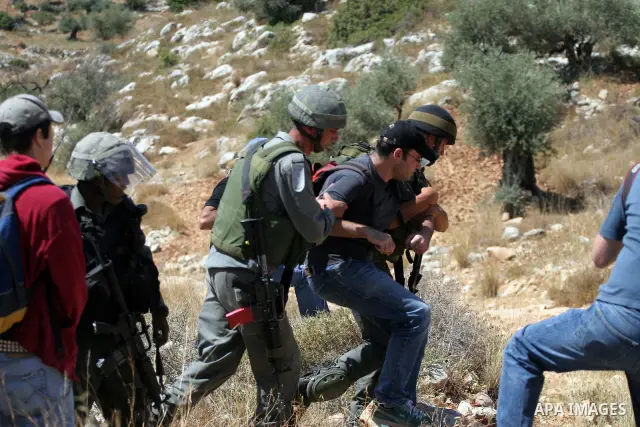 Israeli border police scuffle with Palestinians and international peace protesters during a demonstration against the construction of the controversial Israeli barrier in the West Bank village of Nilleen near Ramallah.