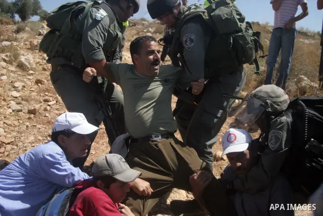 Israeli border police scuffle with Palestinians and international peace protesters during a demonstration against the construction of the controversial Israeli barrier in the West Bank village of Nilleen near Ramallah.