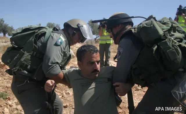 Israeli border police scuffle with Palestinians and international peace protesters during a demonstration against the construction of the controversial Israeli barrier in the West Bank village of Nilleen near Ramallah.