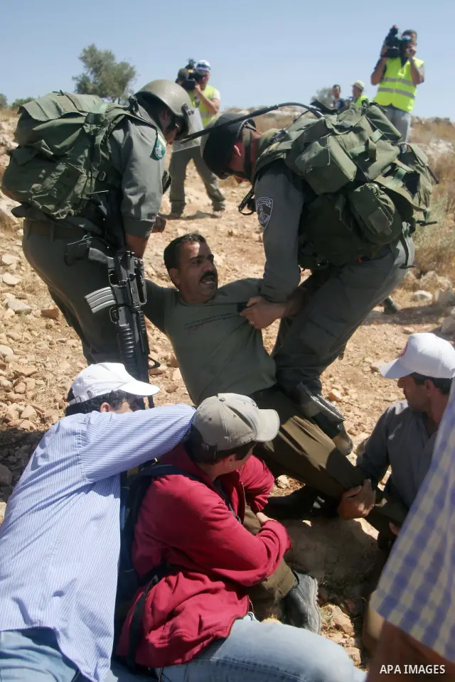 Israeli border police scuffle with Palestinians and international peace protesters during a demonstration against the construction of the controversial Israeli barrier in the West Bank village of Nilleen near Ramallah.