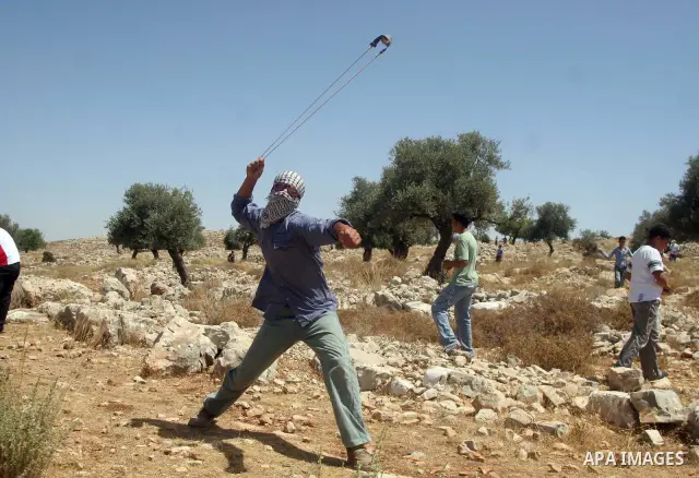 Palestinian youths throw stones at Israeli border police officers during a protest against the construction of Israel's controversial barrier in the West Bank village of Nilleen, near Ramallah.