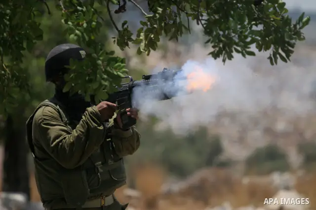 Israeli border policemen officers fire teargas at Palestinian stone-throwers during a violent protest against the construction of Israel's controversial security fence in the West Bank village of Nilin, west of Ramallah.