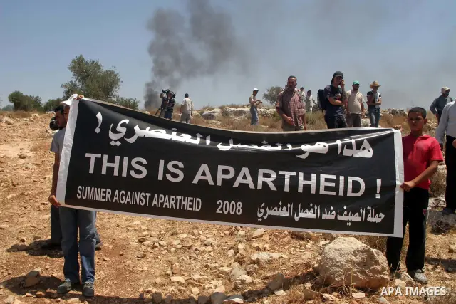 Palestinians hold placard during a demonstration against the construction of Israel's disputed barrier in the West Bank village of Nilleen near Ramallah.