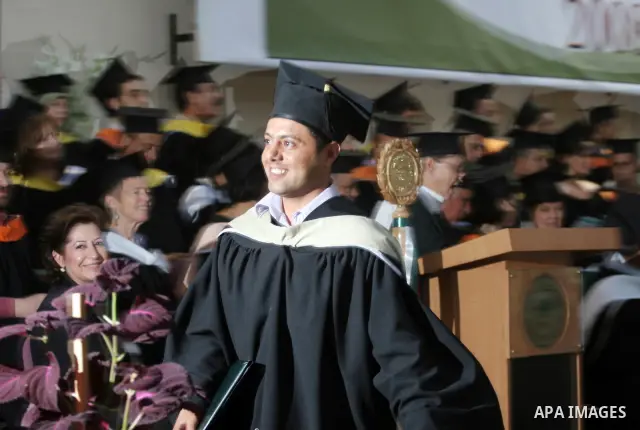 Palestinian students hold their graduation certificates as they celebrate at a graduation ceremony in Birzeit University near the West Bank city of Ramallah.