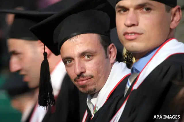 Palestinian students hold their graduation certificates as they celebrate at a graduation ceremony in Birzeit University near the West Bank city of Ramallah.
