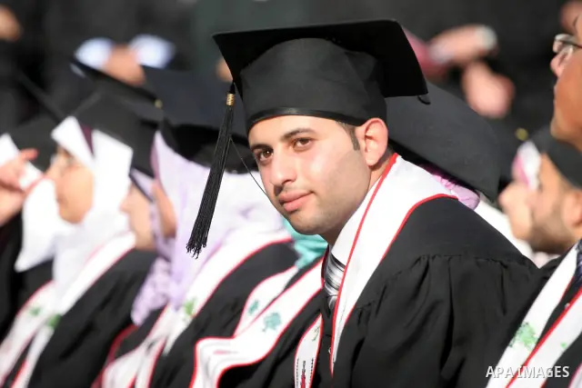 Palestinian students hold their graduation certificates as they celebrate at a graduation ceremony in Birzeit University near the West Bank city of Ramallah.
