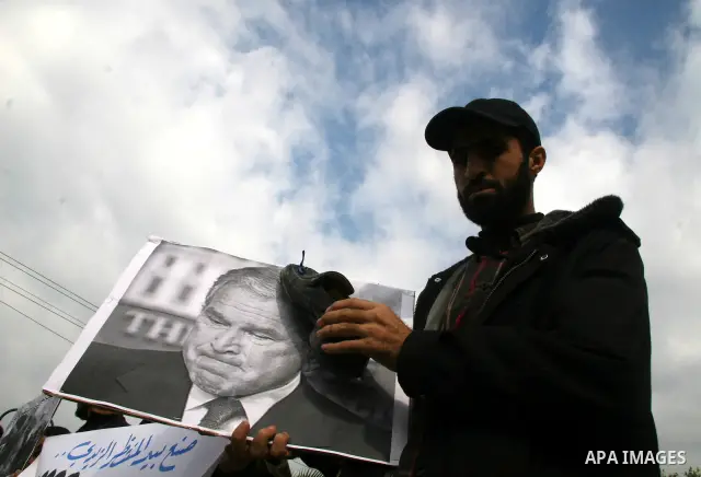 Palestinian militants burn a U.S and Israeli flag during a protest in Gaza. The protest, organised by popular resistant committees, was held in solidarity with Iraqi TV reporter Muntazer al-Zaidi, who threw his shoes at...