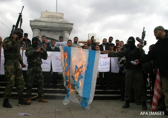 Palestinian militants burn a U.S and Israeli flag during a protest in Gaza. The protest, organised by popular resistant committees, was held in solidarity with Iraqi TV reporter Muntazer al-Zaidi, who threw his shoes at...