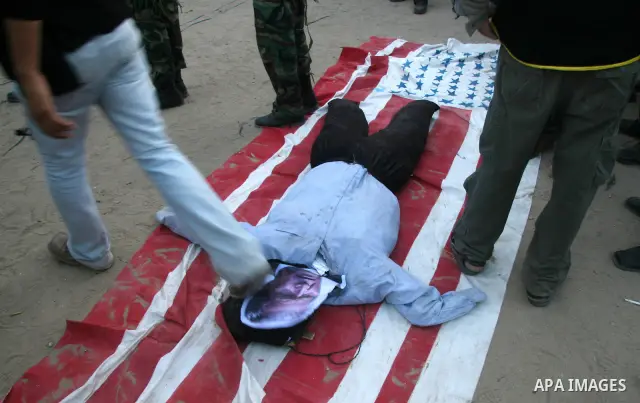 An effigy representing US President George W. Bush burns along with a US flag during a rally by Palestinian militants of the Saraya Al-Quds (Jerusalem Brigades,) the military wing of the Islamic Jihad, in Gaza City. Tens...