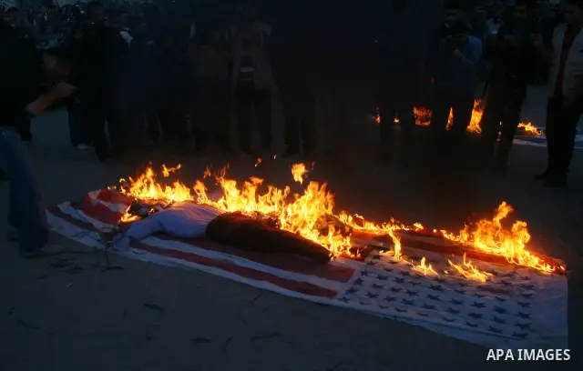 An effigy representing US President George W. Bush burns along with a US flag during a rally by Palestinian militants of the Saraya Al-Quds (Jerusalem Brigades,) the military wing of the Islamic Jihad, in Gaza City. Tens...