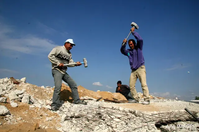 Palestinian workers collect scrap iron from the destroyed houses and companies near Erez crossing northern of Gaza Strip,on December 23,2008. Palestinian armed groups in Gaza observed a 24-hour halt to rocket fire agains...