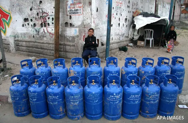 A Palestinian boy sells cylinders of cooking gas, smuggled into the Gaza Strip from Egypt through a tunnel, on a street in Gaza City, Gaza Strip. Palestinian armed groups in Gaza observed a 24-hour halt to rocket fire ag...