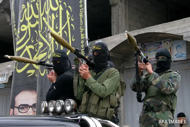 Masked Palestinian militants hold their weapons during an Islamic Jihad rally in Bureij, central Gaza Strip, Friday, Dec. 26, 2008. Israeli defense officials say politicians have approved a large-scale incursion into the...
