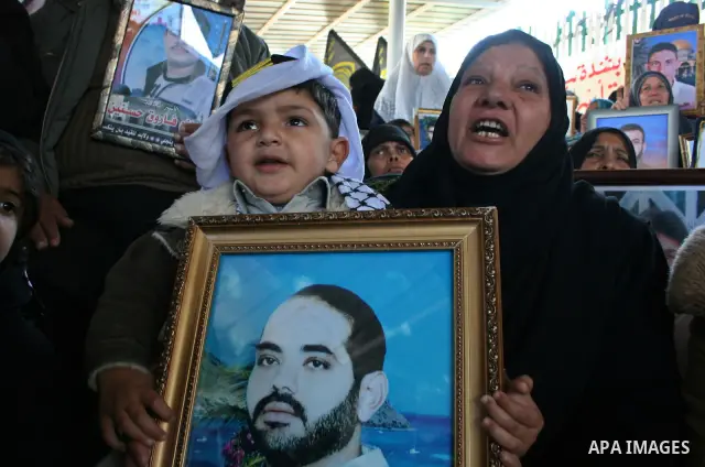 Palestinians gather as holding a pictures of relatives held in Israeli Jails during a weekly demonstration calling for their release at the Red Cross headquarters in Gaza City.