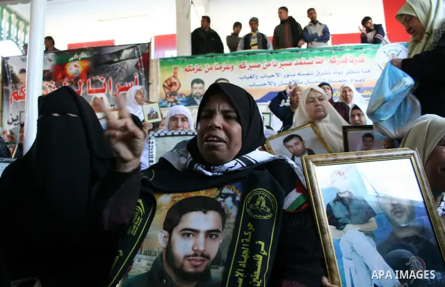 Palestinians gather as holding a pictures of relatives held in Israeli Jails during a weekly demonstration calling for their release at the Red Cross headquarters in Gaza City.