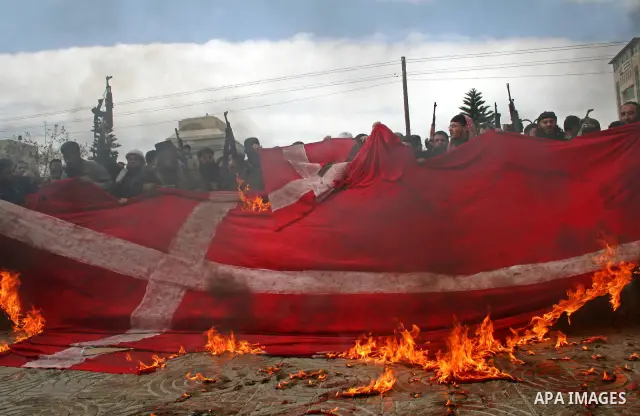 Palestinians burn a flag of Denmark during a protest in Gaza. The rally, organised by popular resistant committees, was a protest against a cartoon of Prophet Mohammad that was republished by Danish newspapers on Februar...
