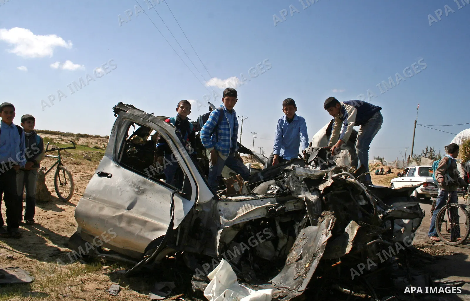 Palestinians inspect a destroyed vehicle belonging to Hamas Police after it was targeted by an Israeli air strike in the southern Gaza Strip February 27, 2008. Israeli air strikes killed at least six Palestinians in the...
