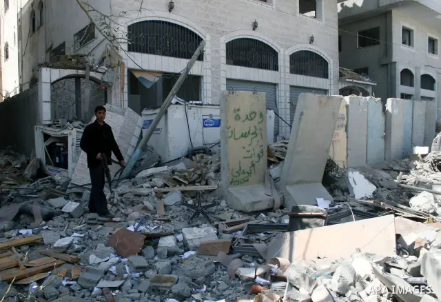 Hamas policemen stand in front of a destroyed Hamas-run Interior Ministry in Gaza February 28, 2008, after it was bombed by Israeli military aircraft. Israeli Prime Minister Ehud Olmert vowed Thursday to make Hamas milit...