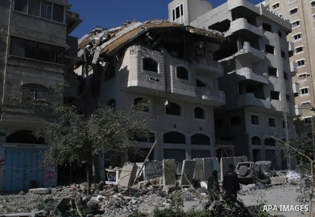 Hamas policemen walk past a destroyed Hamas-run Interior Ministry in Gaza February 28, 2008, after it was bombed by Israeli military aircraft. Israeli Prime Minister Ehud Olmert vowed Thursday to make Hamas militants pay...
