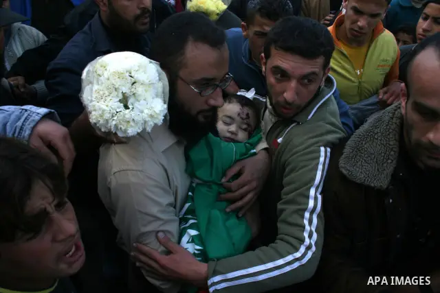 The father of six-month-old Mohammed Bourai carries his dead son to his funeral in Gaza City on February 28, 2008, following his death in an Israeli airstrike on a building housing the Hamas-run government's interior min...