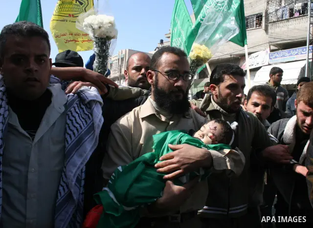 The father of six-month-old Mohammed Bourai carries his dead son to his funeral in Gaza City on February 28, 2008, following his death in an Israeli airstrike on a building housing the Hamas-run government's interior min...