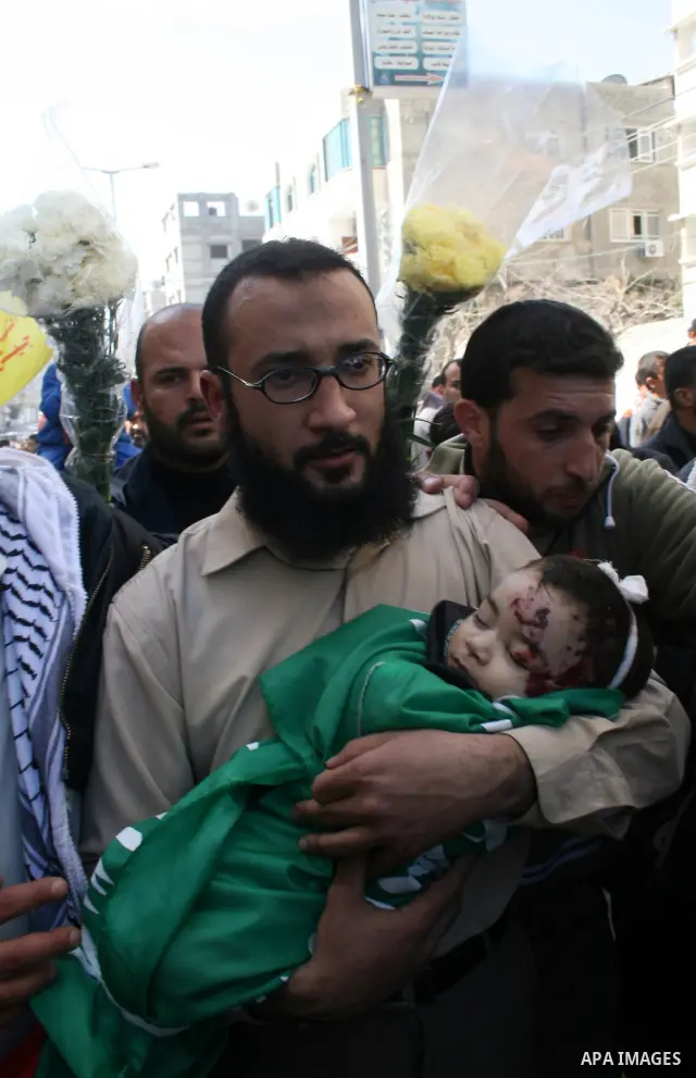 The father of six-month-old Mohammed Bourai carries his dead son to his funeral in Gaza City on February 28, 2008, following his death in an Israeli airstrike on a building housing the Hamas-run government's interior min...