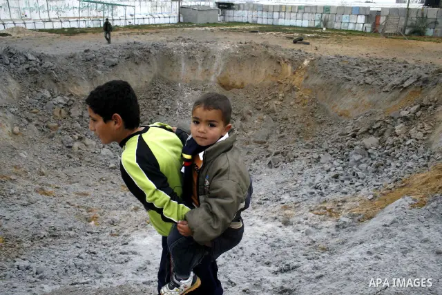 Palestinian children play at Hamas training camp after it was destroyed by Israeli air strike in Rafah, southern Gaza Strip. two Israeli brothers, ages 8 and 19, were seriously wounded when a rocket from Gaza slammed int...