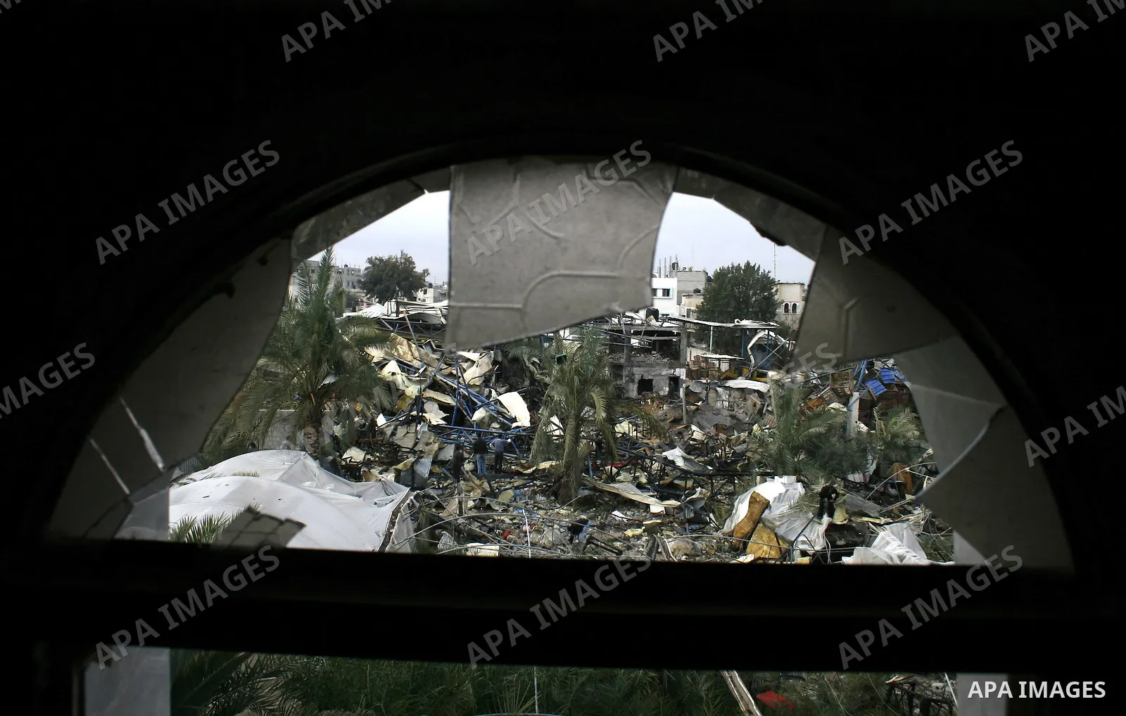 Palestinians inspect in the rubble of a store of food items after it was targeted and demolished by Israeli air strike in Rafah, southern Gaza Strip. two Israeli brothers, ages 8 and 19, were seriously wounded when a roc...