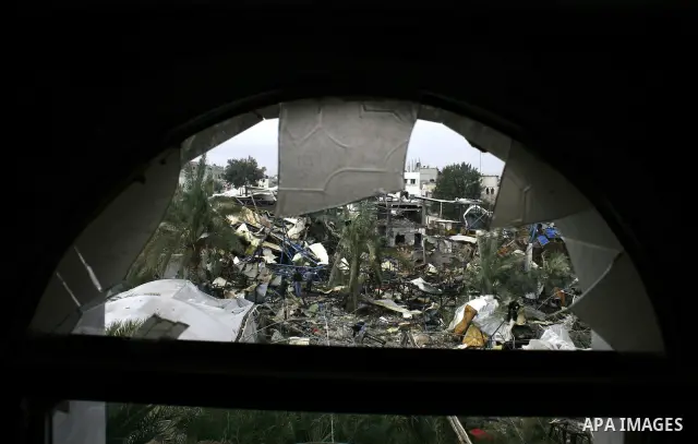 Palestinians inspect in the rubble of a store of food items after it was targeted and demolished by Israeli air strike in Rafah, southern Gaza Strip. two Israeli brothers, ages 8 and 19, were seriously wounded when a roc...