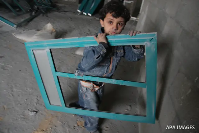 A Palestinian boy inspects the damages inside his shop following an overnight Israeli strike which targeted the nearby labour syndicate headquarters in Gaza City. Israeli Deputy Defence Minister Matan Vilnai warned today...