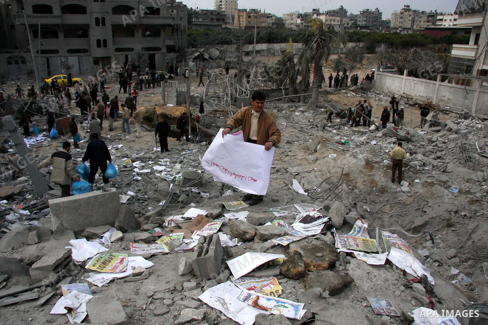 Palestinians inspect the destroyed labour syndicate headquarters after it was targeted by Israeli airstrike, in Gaza City. Israeli Deputy Defence Minister Matan Vilnai warned today that Israel would keep up its deadly ra...
