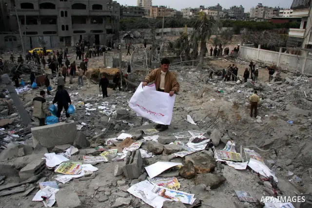 Palestinians inspect the destroyed labour syndicate headquarters after it was targeted by Israeli airstrike, in Gaza City. Israeli Deputy Defence Minister Matan Vilnai warned today that Israel would keep up its deadly ra...