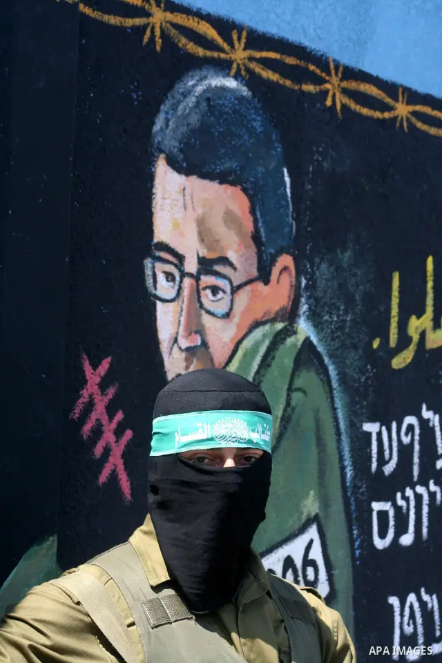 Hamas militantes stand nexta paint a mural depicting captured Israeli soldier Gilad Shalit during a rally demanding the release of Palestinian prisoners from Israeli jails in the Jablia refugee camp, northern Gaza Strip,...