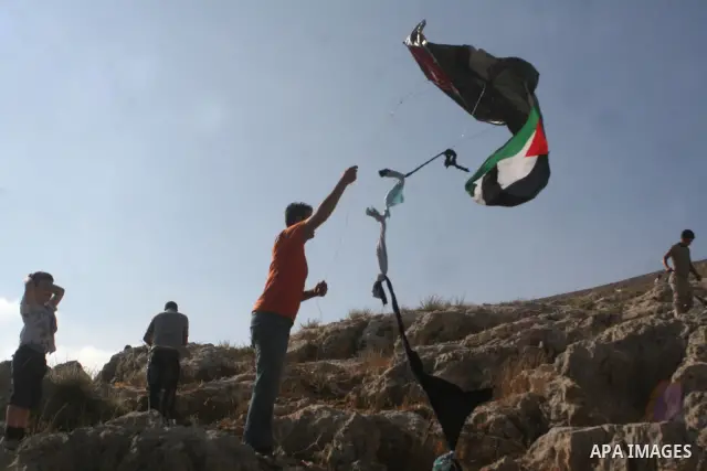 A Palestinians flying balloons over the Israeli settlement of Yitzhar during a demonstration in the village of Burin in the West Bank near the city of Nablus on July 7, 2009. Photo by Nedal Shtieh